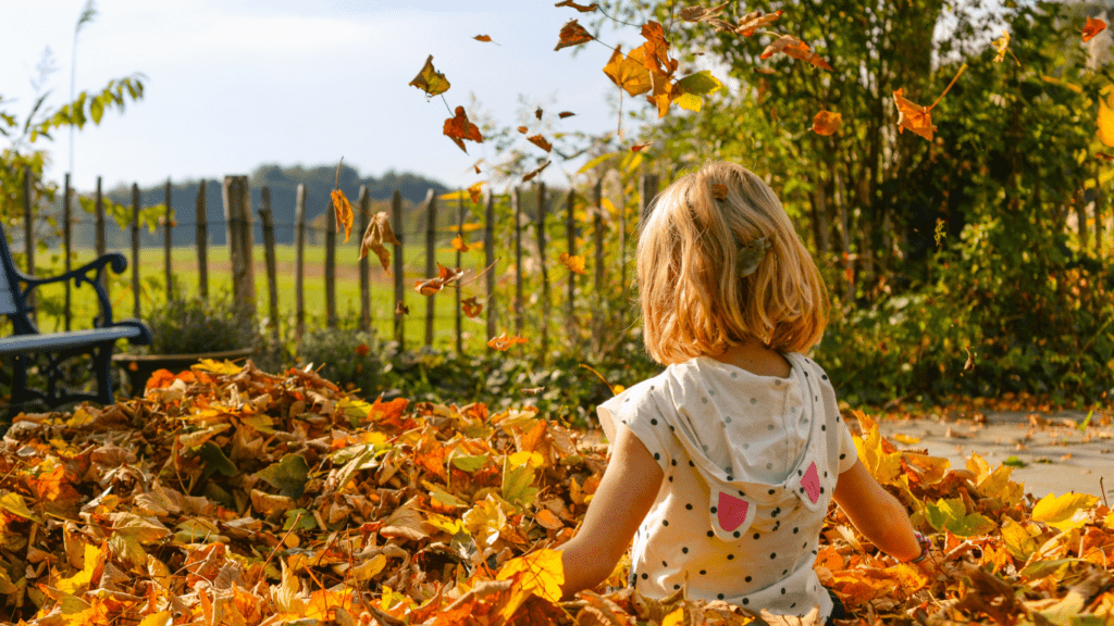 Kid playing with autumn leaves